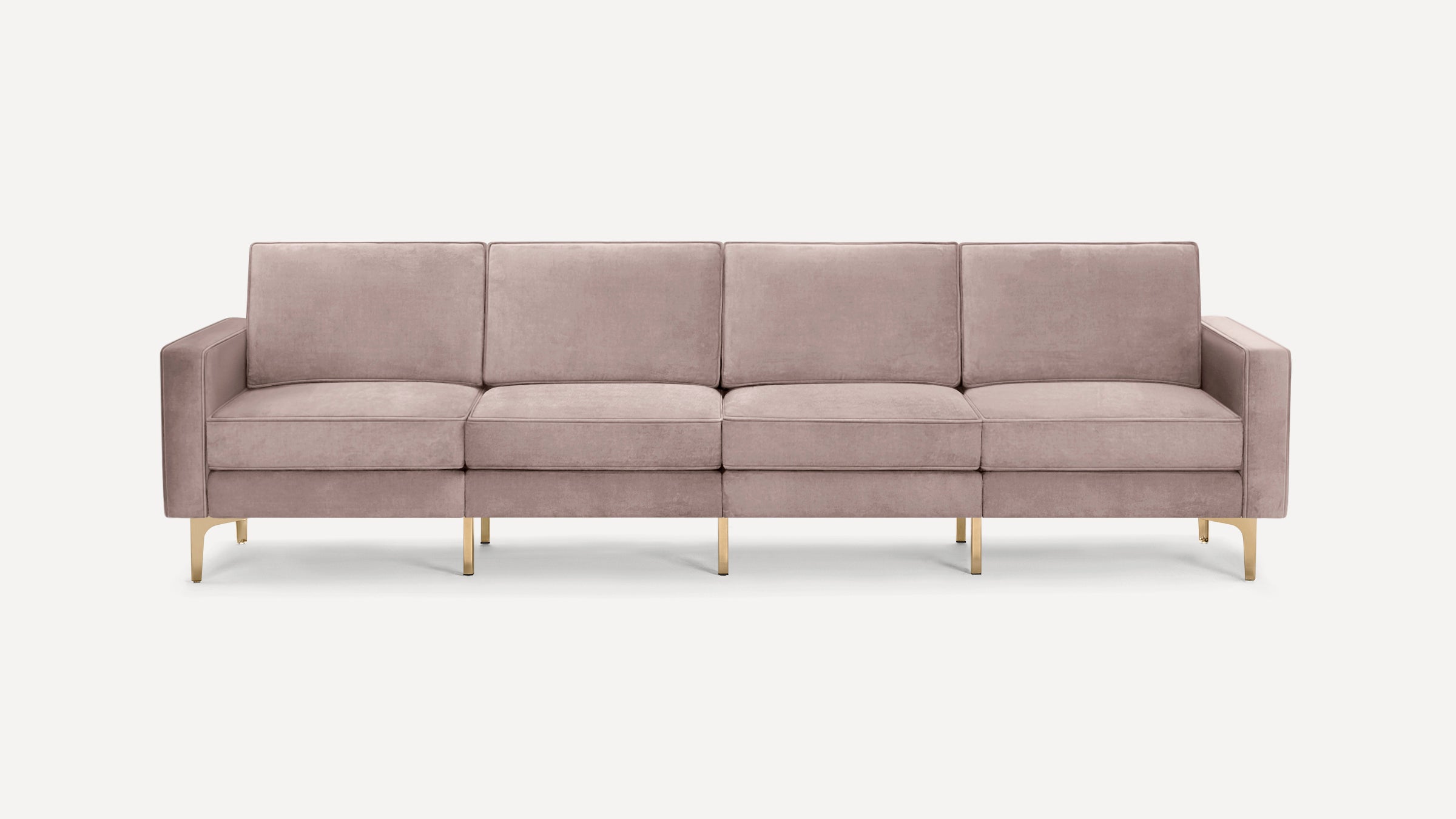 Four-seater modern sofa with blush pink velvet upholstery and sleek gold metal legs on white background.