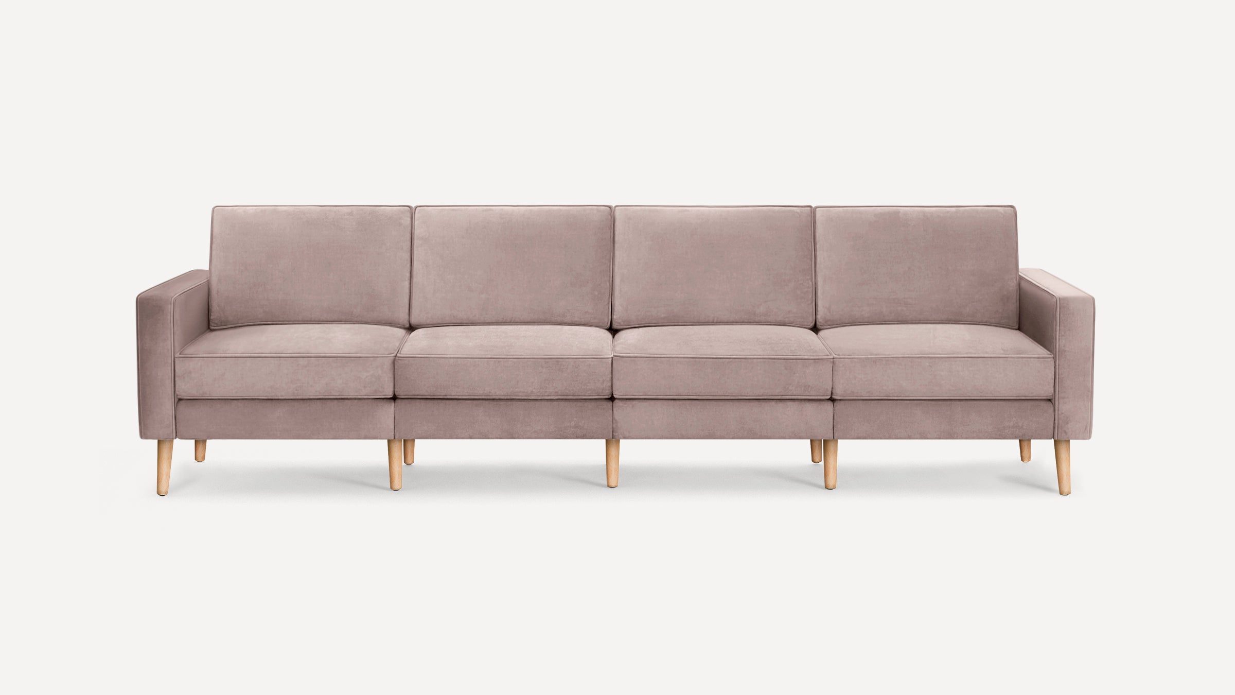 Modern four-seat sofa with soft mauve upholstery and light wooden legs, featuring clean lines and padded armrests.
