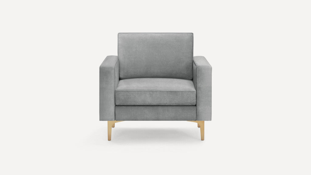 Modern grey velvet armchair with square arms and gold metal legs, pictured on a white background.