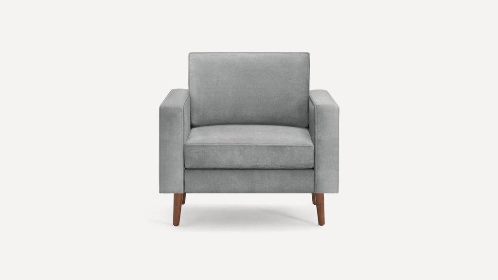 Front view of a modern gray upholstered armchair with wooden legs on a white background.