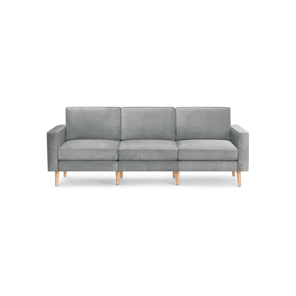 modern light gray velvet sofa with wooden legs and back cushions, featuring a three - cushioned sofa with clean lines and clean lines