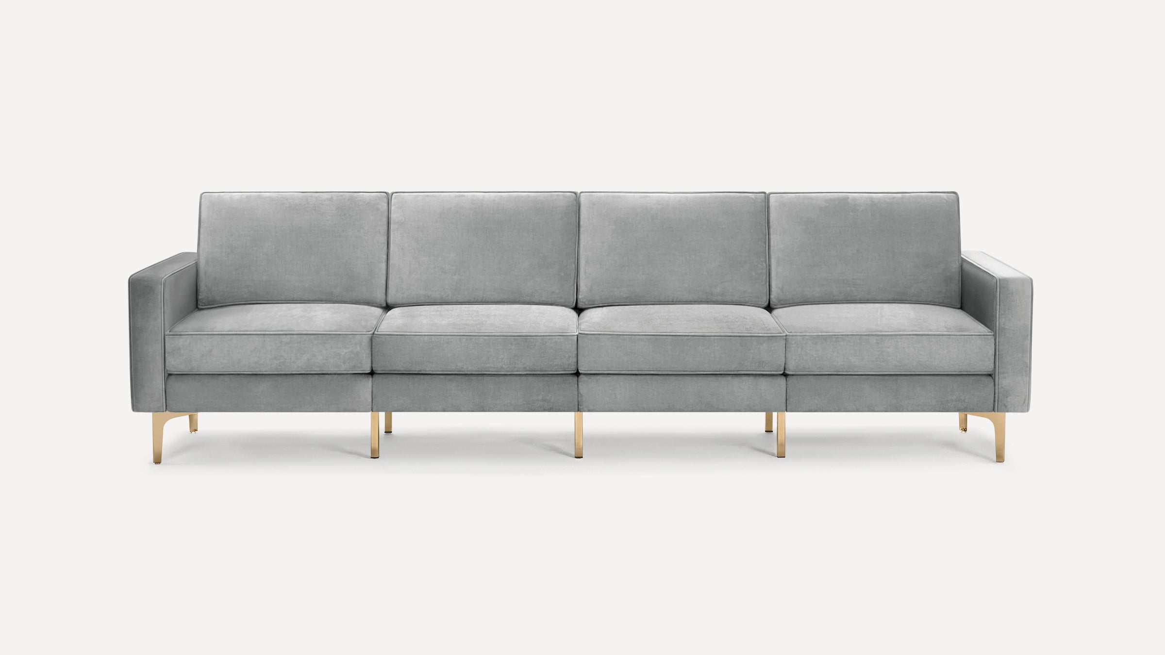 Modern four-seater sofa with light gray velvet upholstery and sleek gold metal legs, featuring clean lines and cushioned armrests.
