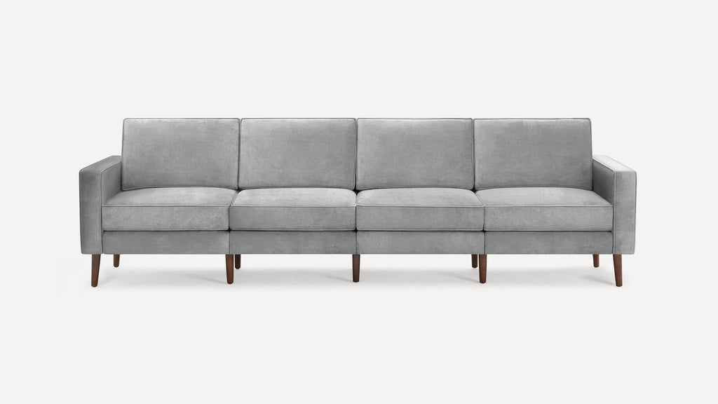 Modern light gray fabric sofa with clean lines, four seat and back cushions, and slender wooden legs.