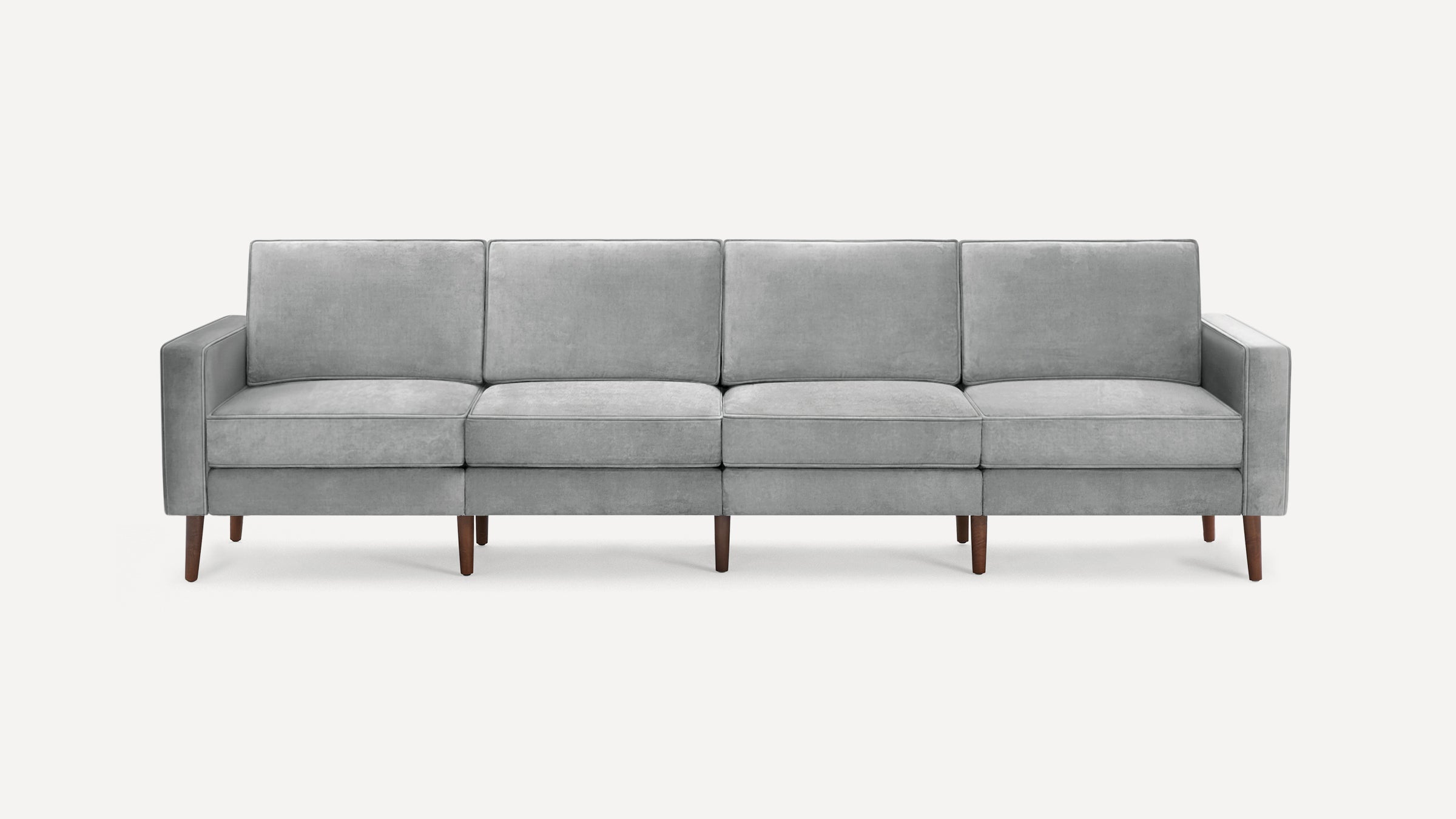 Modern light gray fabric sofa with clean lines, four seat and back cushions, and slender wooden legs.
