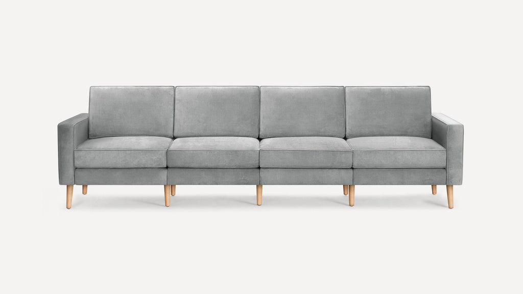 Four-seater modern gray fabric sofa with clean lines, wooden legs, and cushioned back and seat for comfort.