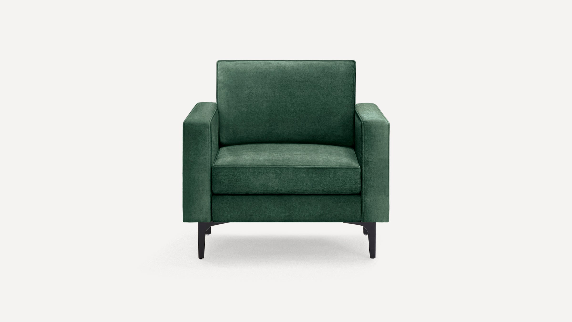Dark green velvet armchair with square arms and black metal legs, shown against a white background.