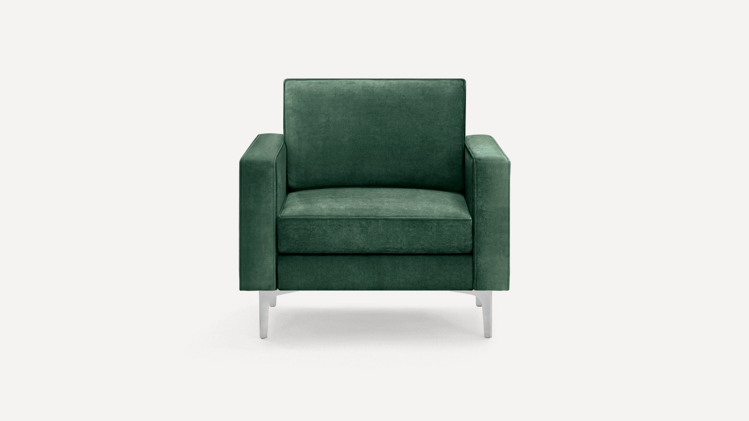 Modern dark green velvet armchair with square arms and slim silver metal legs, shown against a plain white background.