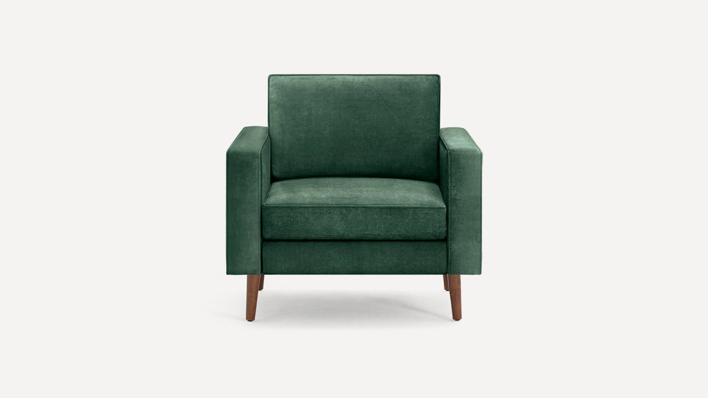 Front view of a modern, dark green upholstered armchair with wooden legs and square armrests on a white background.