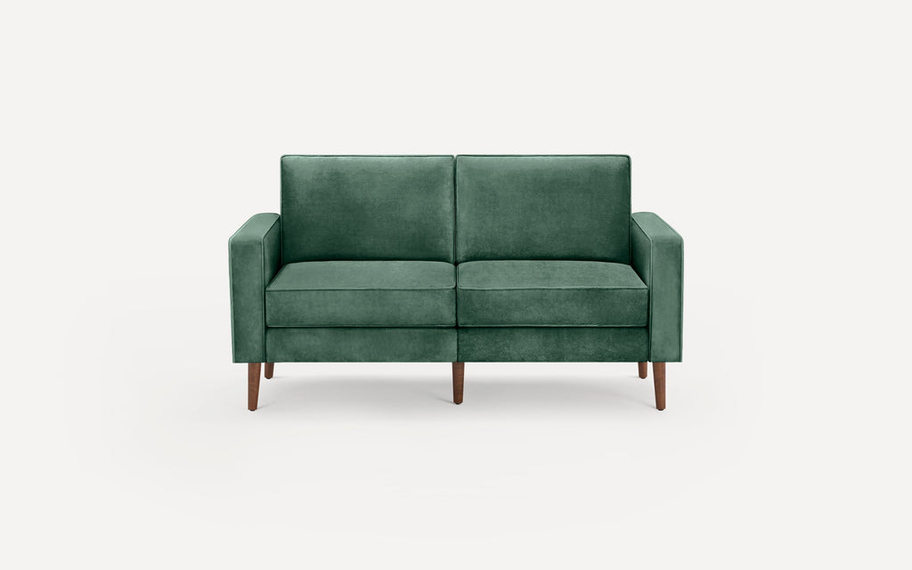 Green velvet two-seater sofa with clean lines, square arms, and tapered wooden legs, set against a white background.