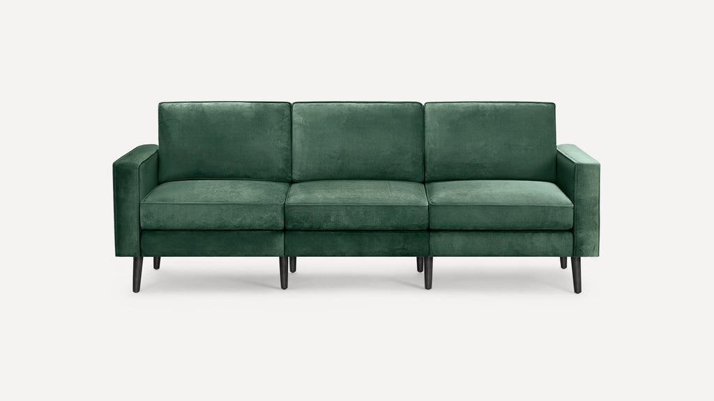 Modern three-seater sofa upholstered in dark green velvet fabric with clean lines, square arms, and black tapered wooden legs.
