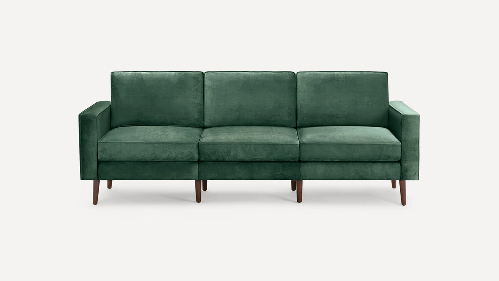 Three-seater green velvet sofa with clean lines, square arms, and mid-century style wooden legs.