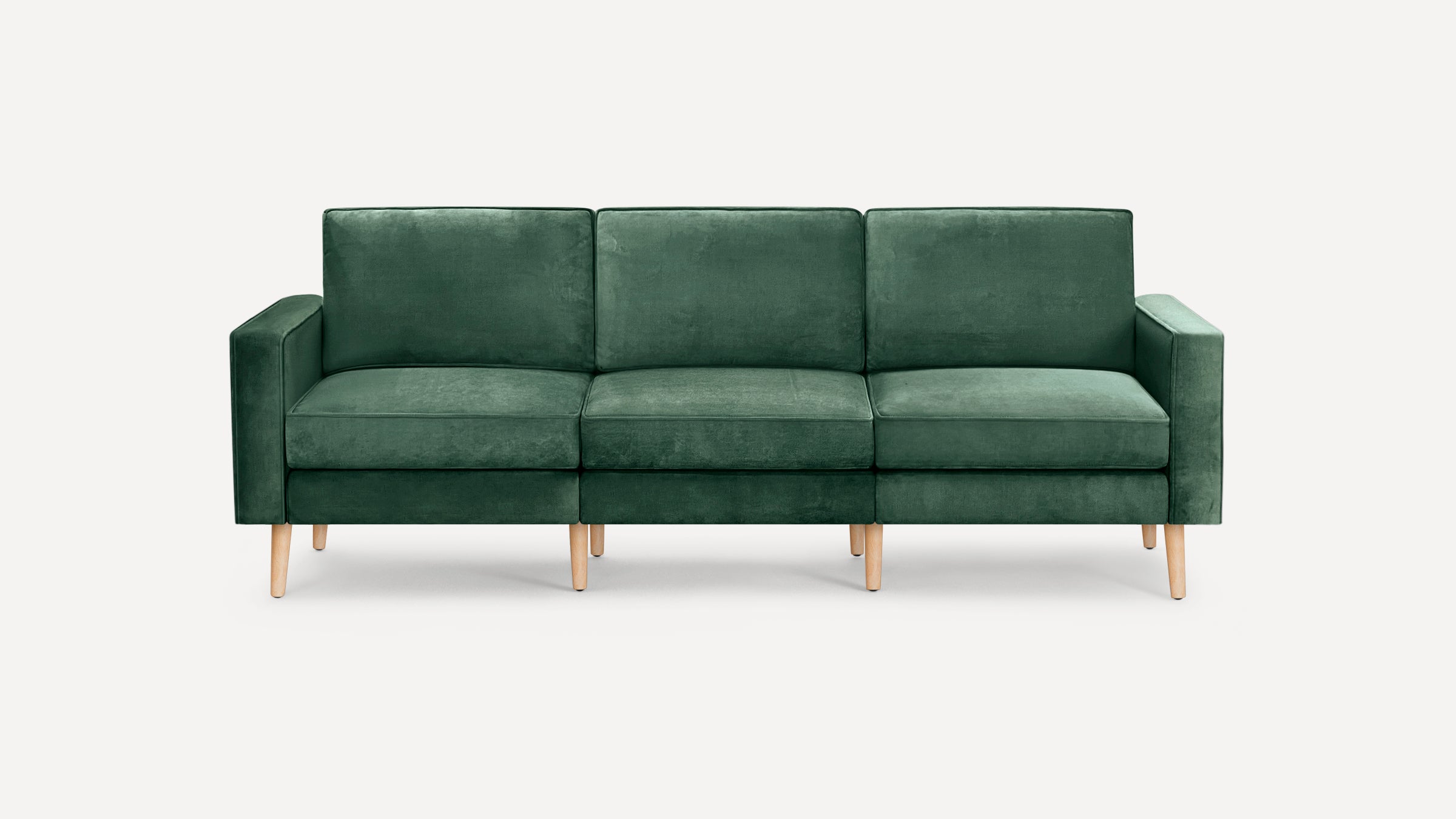 Modern three-seater sofa with deep green velvet upholstery and light wooden tapered legs, featuring clean lines and square armrests.