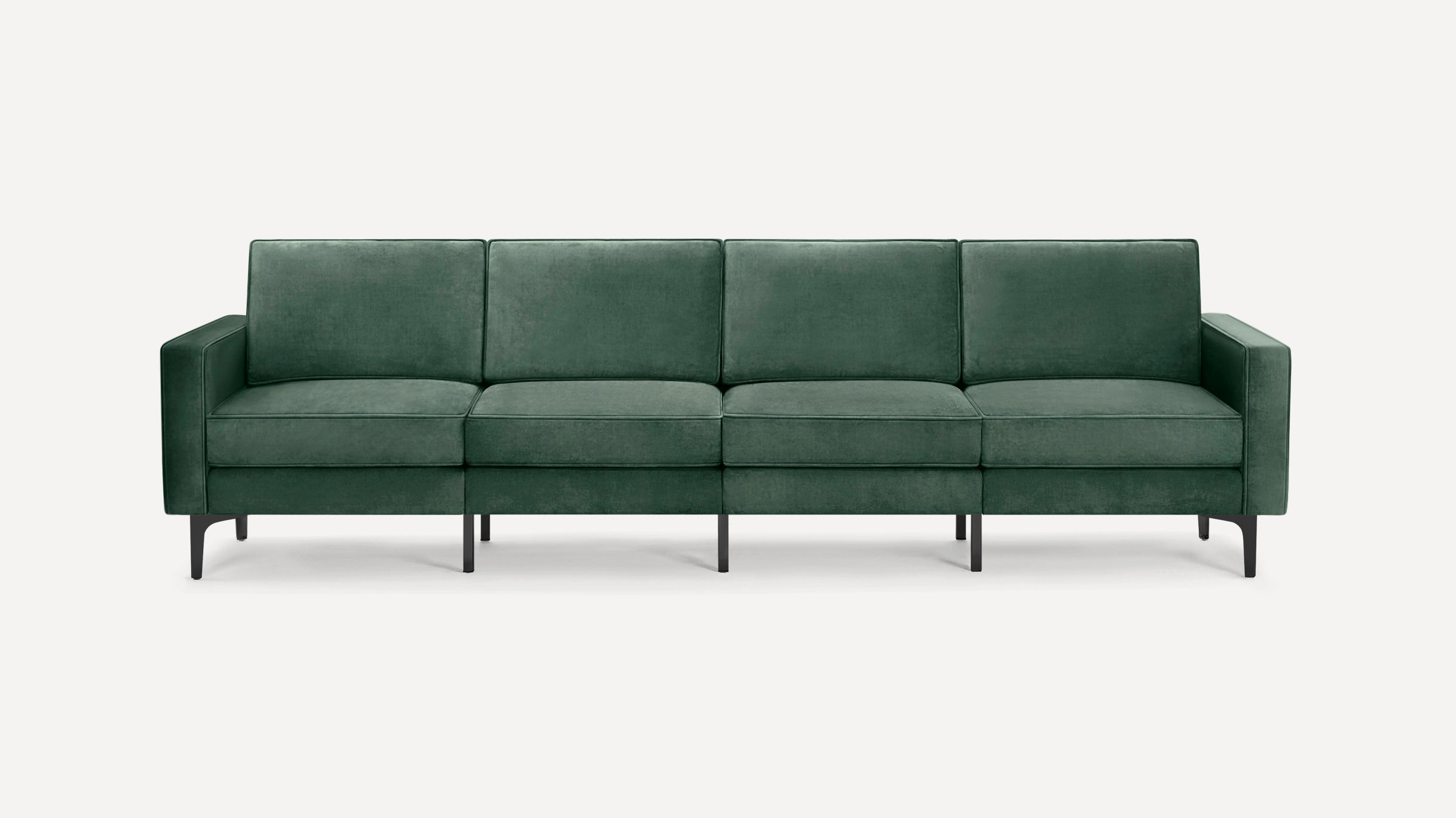Modern four-seater sofa upholstered in dark green velvet fabric with straight armrests and black metal legs, set against a neutral background.