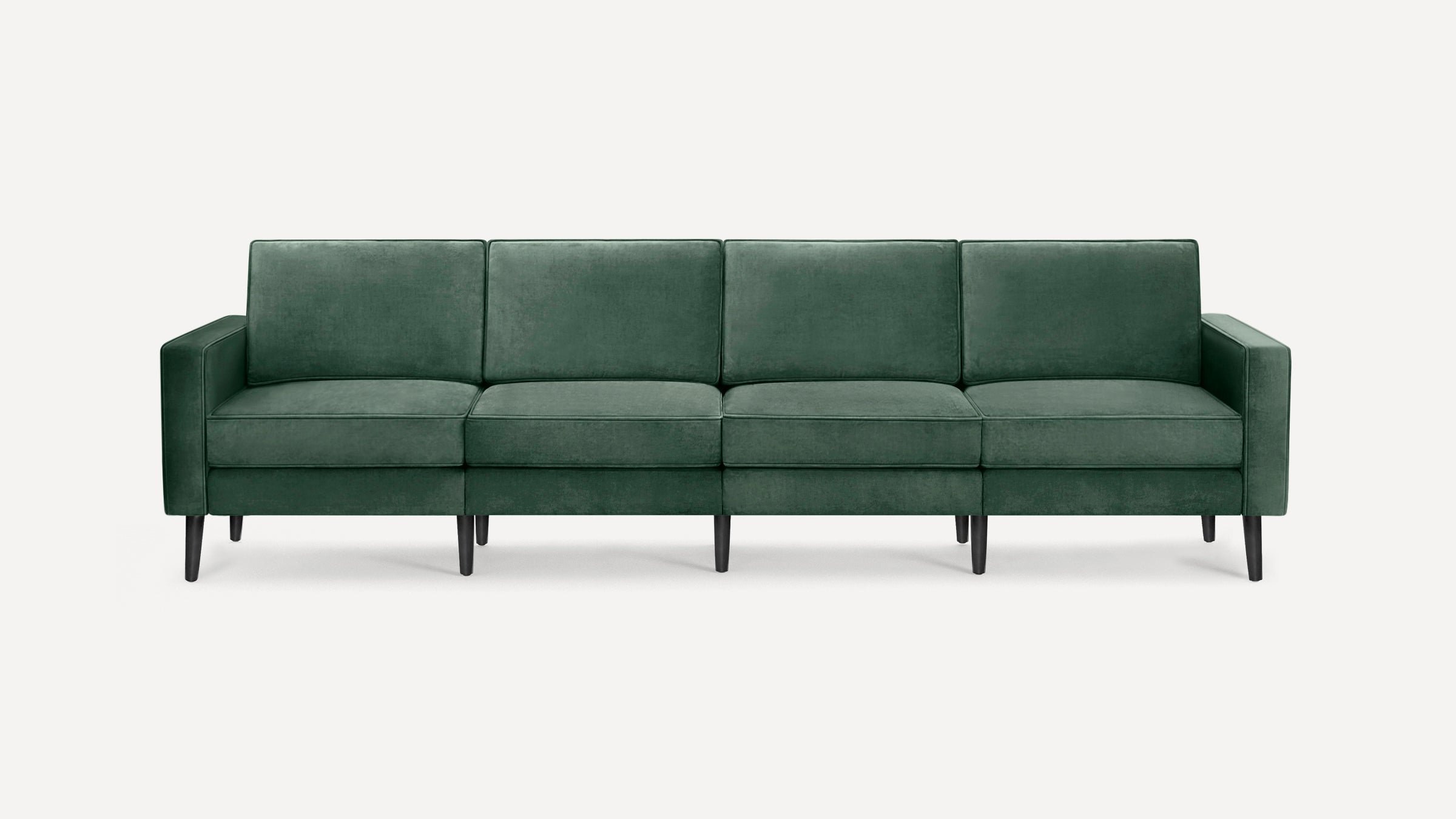 Four-seater modern sofa in dark green velvet upholstery with straight arms and black tapered wooden legs on a white background.