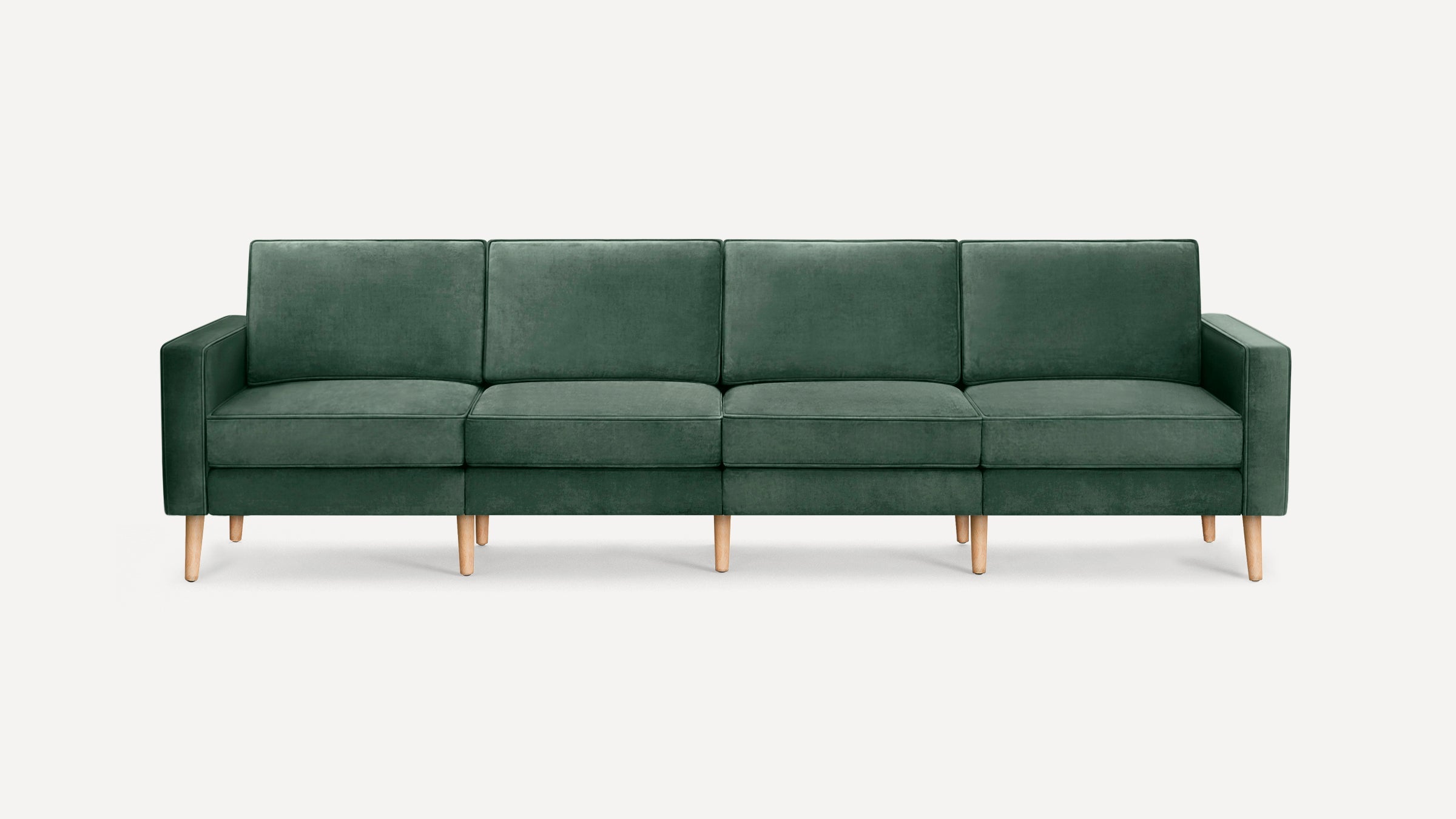 Dark green velvet modern sofa with four seat cushions and light wooden legs, against a plain white background.