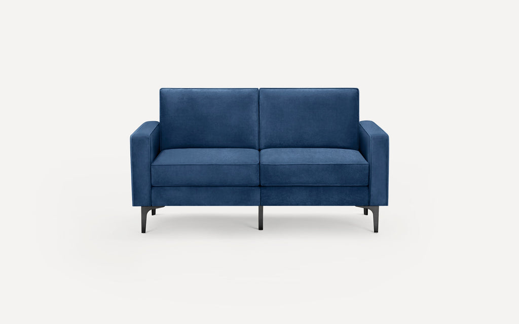 Modern blue velvet two-seater sofa with straight arms and black tapered metal legs on white background.