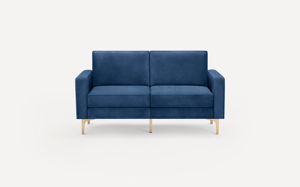 Modern two-seater sofa upholstered in blue velvet fabric with straight armrests and brass-colored metal legs on a white background.