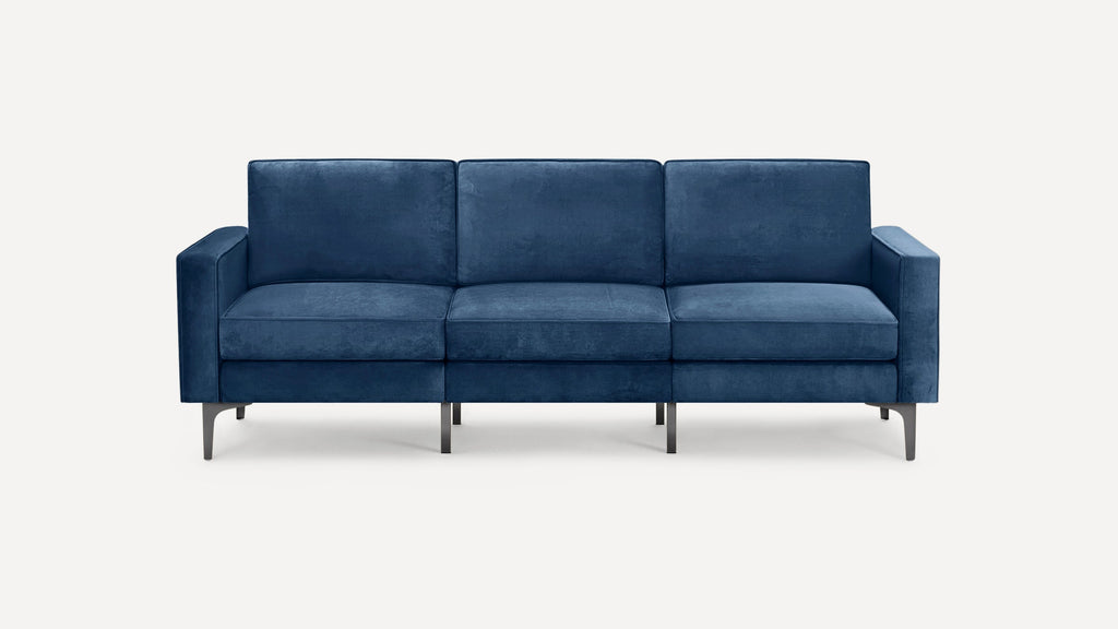 Modern three-seater sofa with deep blue velvet upholstery and sleek metal legs, featuring straight arms and plush cushions.