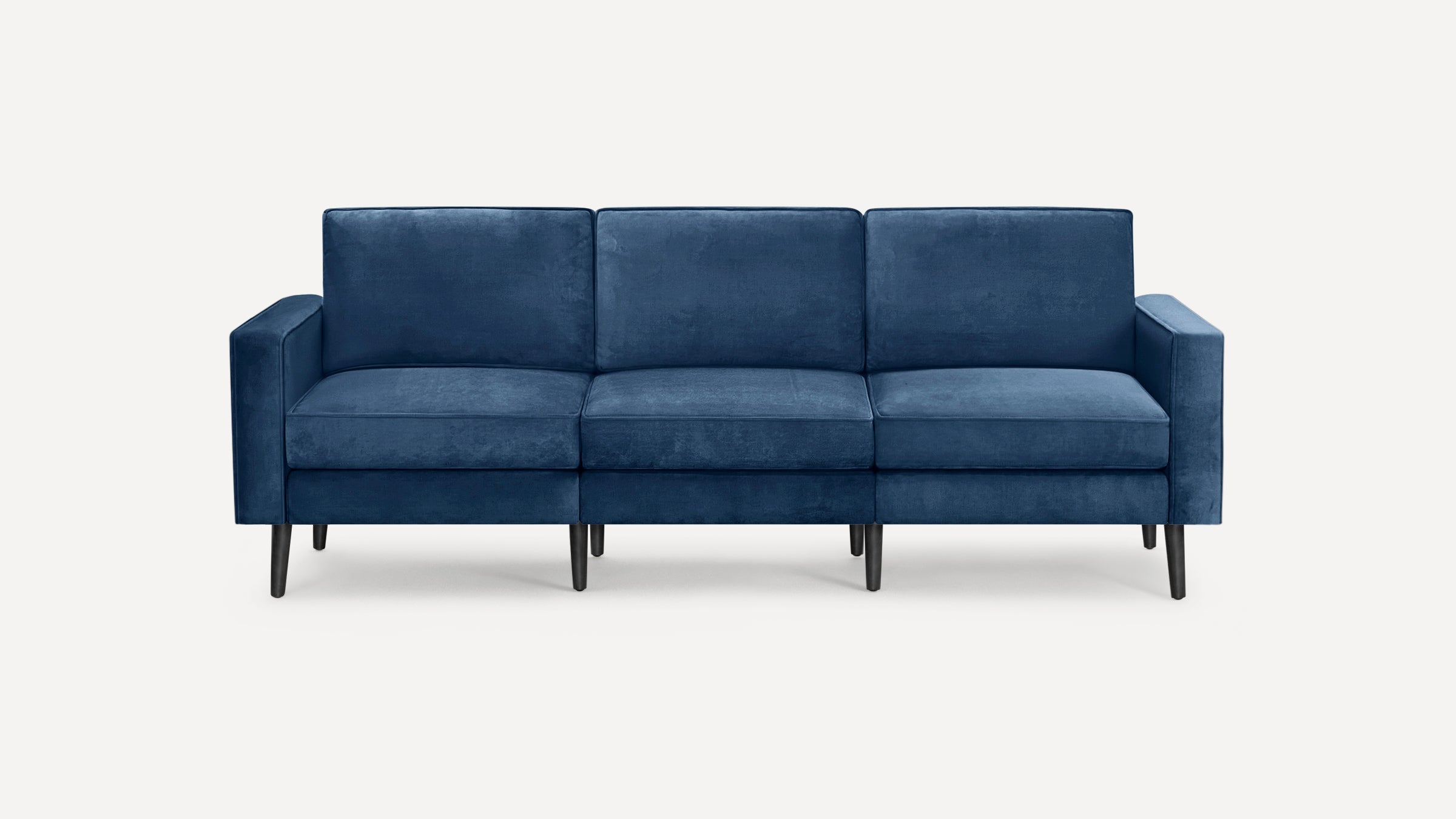Three-seat modern sofa upholstered in dark blue velvet fabric with slim black wooden legs, straight arms, and cushioned seats and backs.