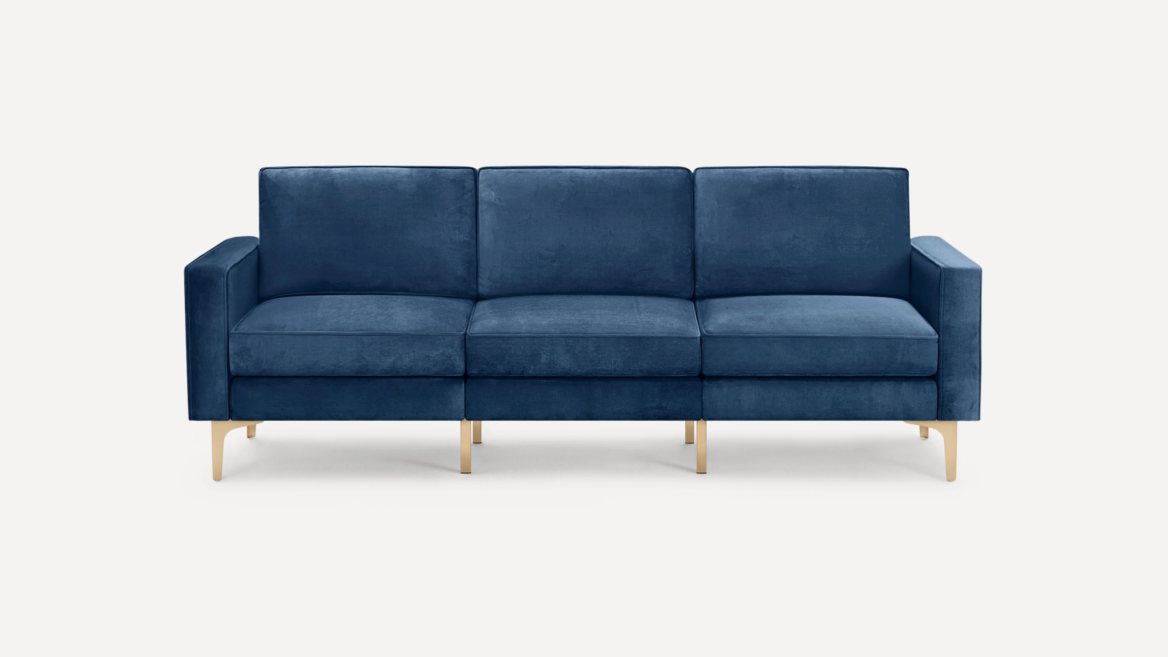 Modern navy blue velvet sofa with three seat cushions, square arms, and sleek gold metal legs, set against a white background.