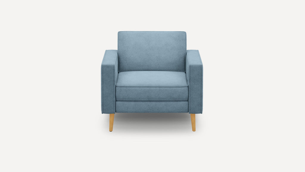 Front view of a modern, blue upholstered armchair with wooden legs on a white background.