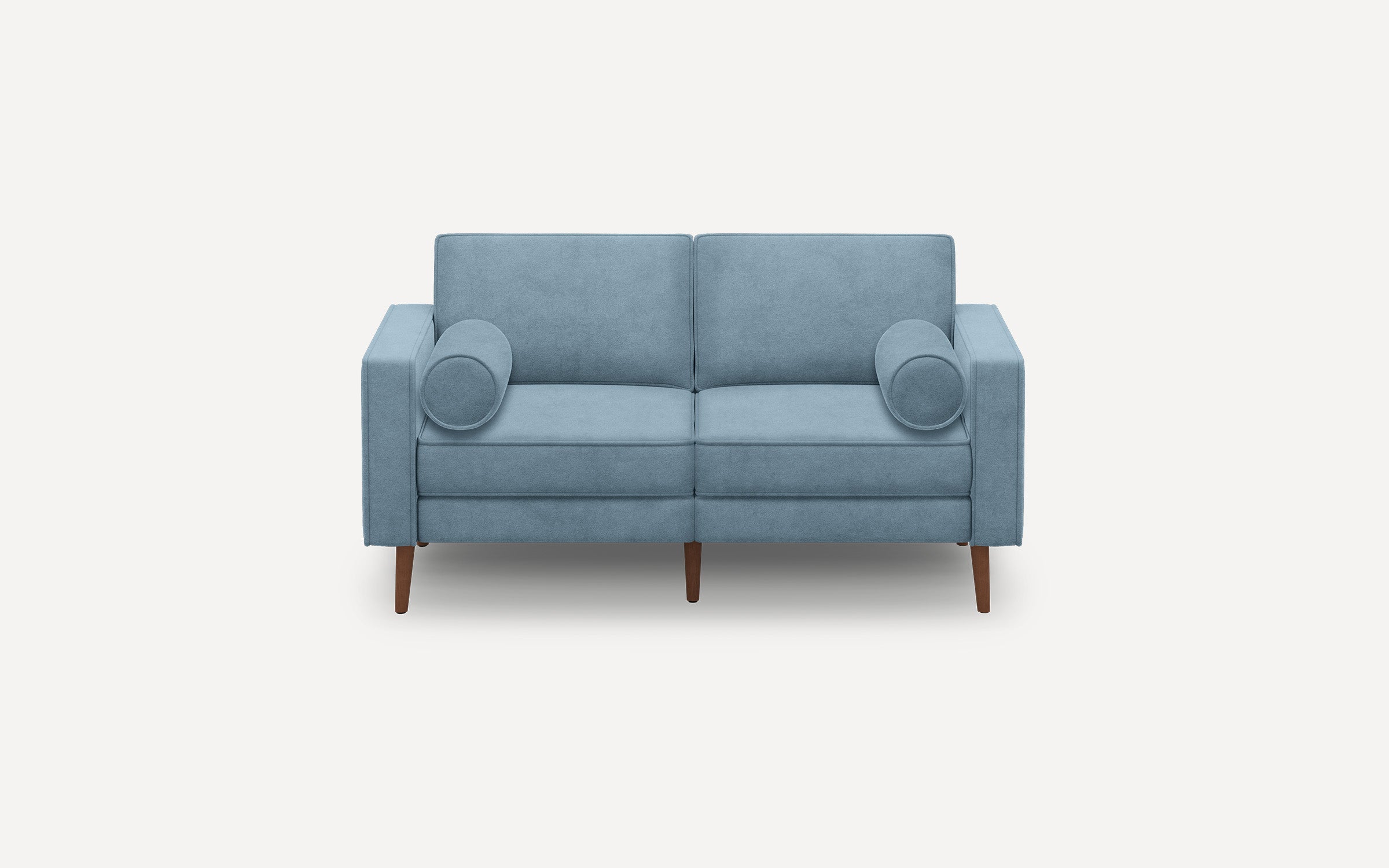 Two-seater modern light blue fabric sofa with clean lines, wooden tapered legs, and two cylindrical matching bolster pillows.