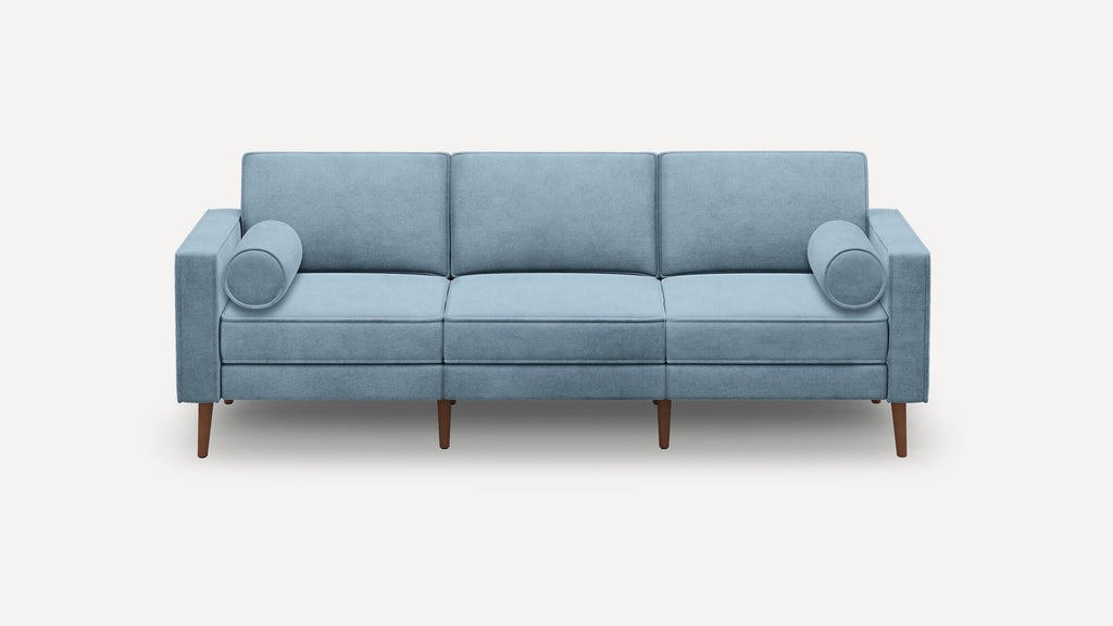 Light blue three-seater sofa with two cylindrical bolster pillows and wooden tapered legs on a white background.