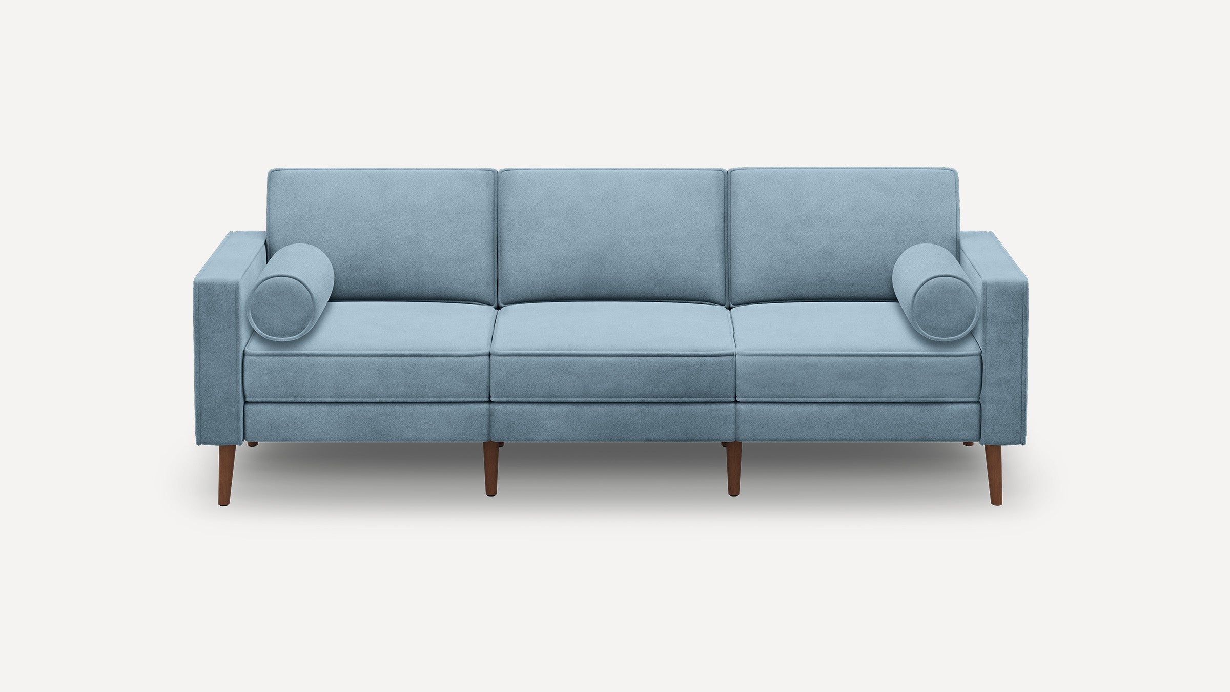 Light blue three-seater sofa with two cylindrical bolster pillows and wooden tapered legs on a white background.