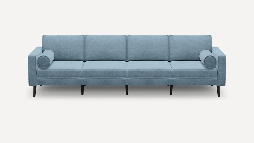 Modern light blue fabric sofa with four seat cushions, two cylindrical bolster pillows, and dark tapered wooden legs.