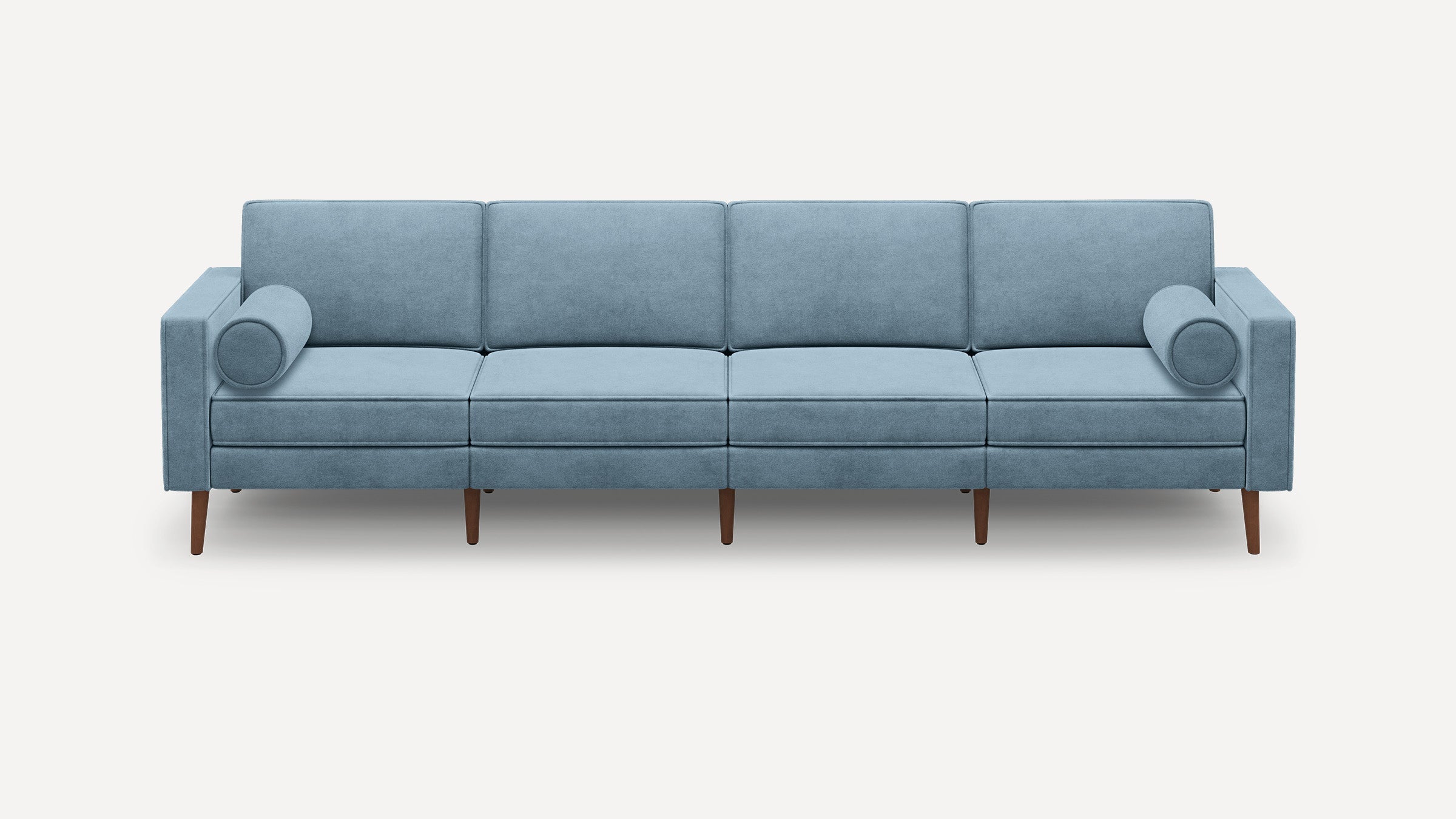 Light blue modern four-seater sofa with clean lines, square arms, cylindrical pillows, and wooden legs on a white background.