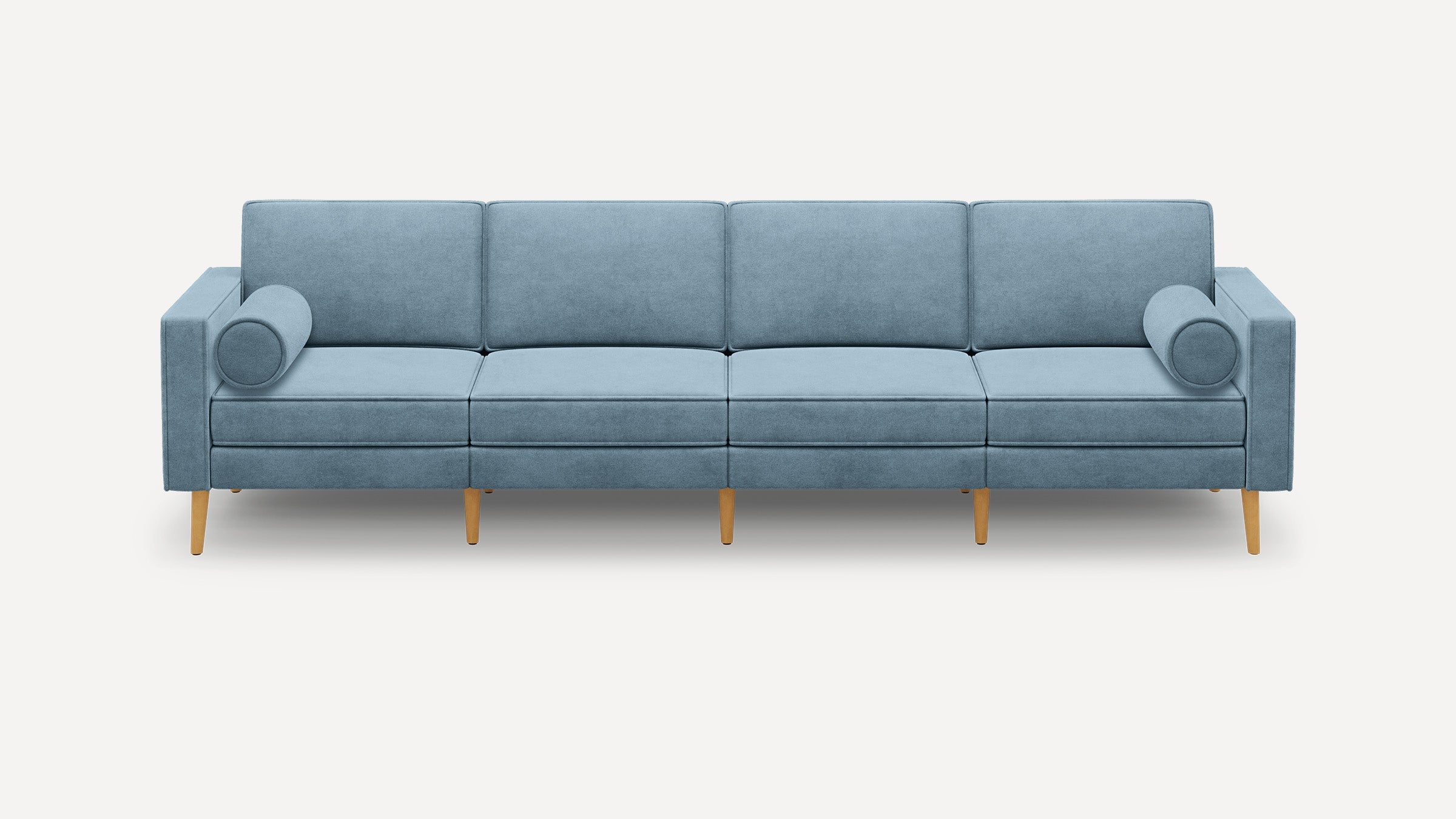 Modern light blue four-seater sofa with rectangular cushions, cylindrical arm pillows, and wooden tapered legs on a white background.
