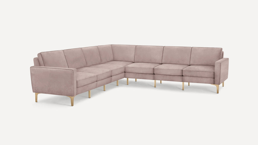 L-shaped modern sectional sofa upholstered in dusty pink fabric with gold metal legs and square tufted cushions.