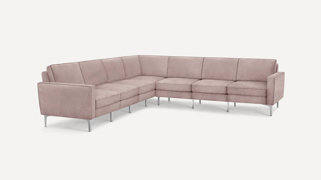 Modern L-shaped sectional sofa with soft pink upholstery and sleek metal legs, featuring clean lines and cushioned seats.