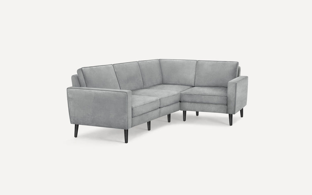 Modern light gray velvet L-shaped sectional sofa with clean lines and slim black tapered legs on white background.
