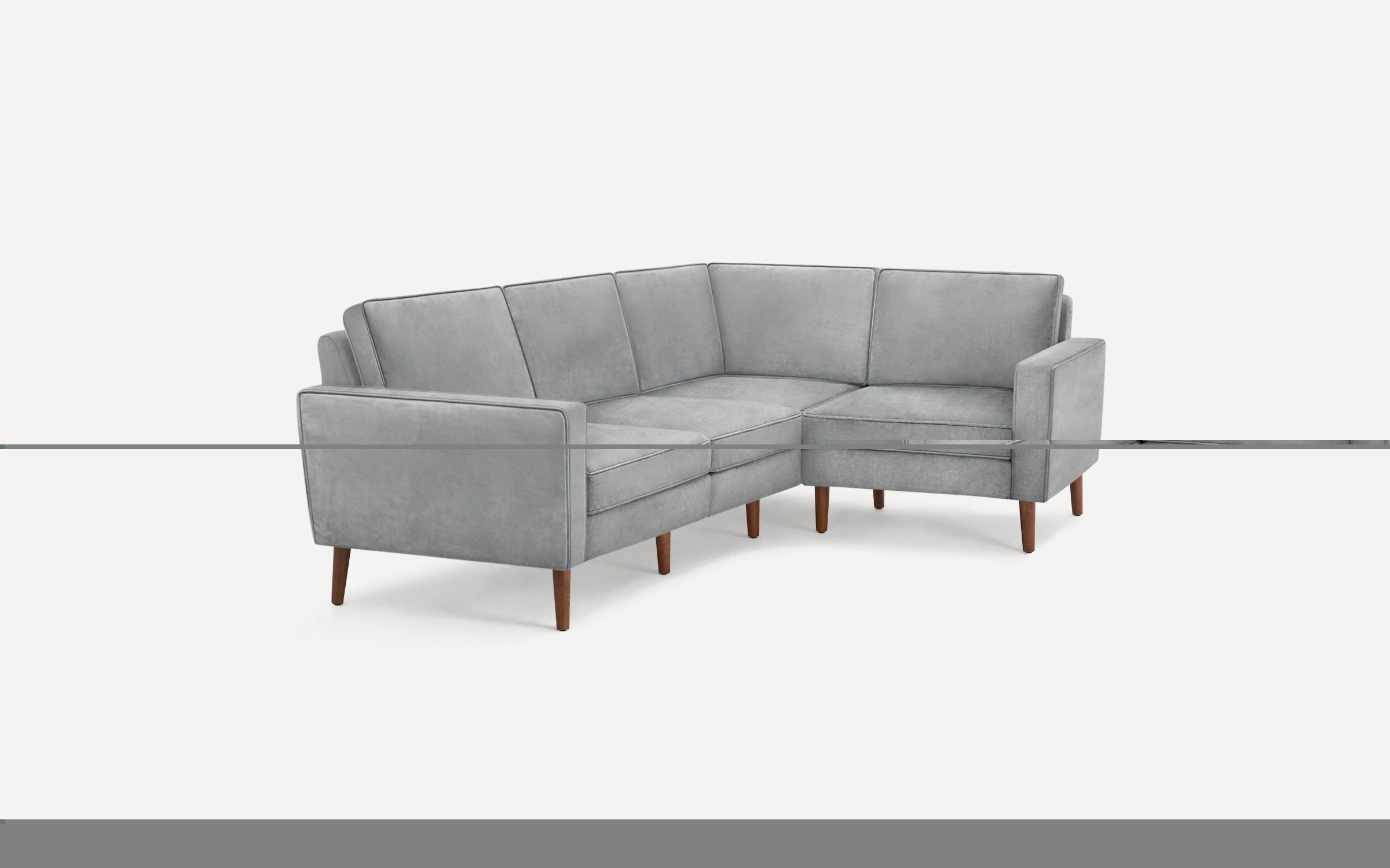 Light gray L-shaped sectional sofa with mid-century wooden legs and cushioned back and seat.