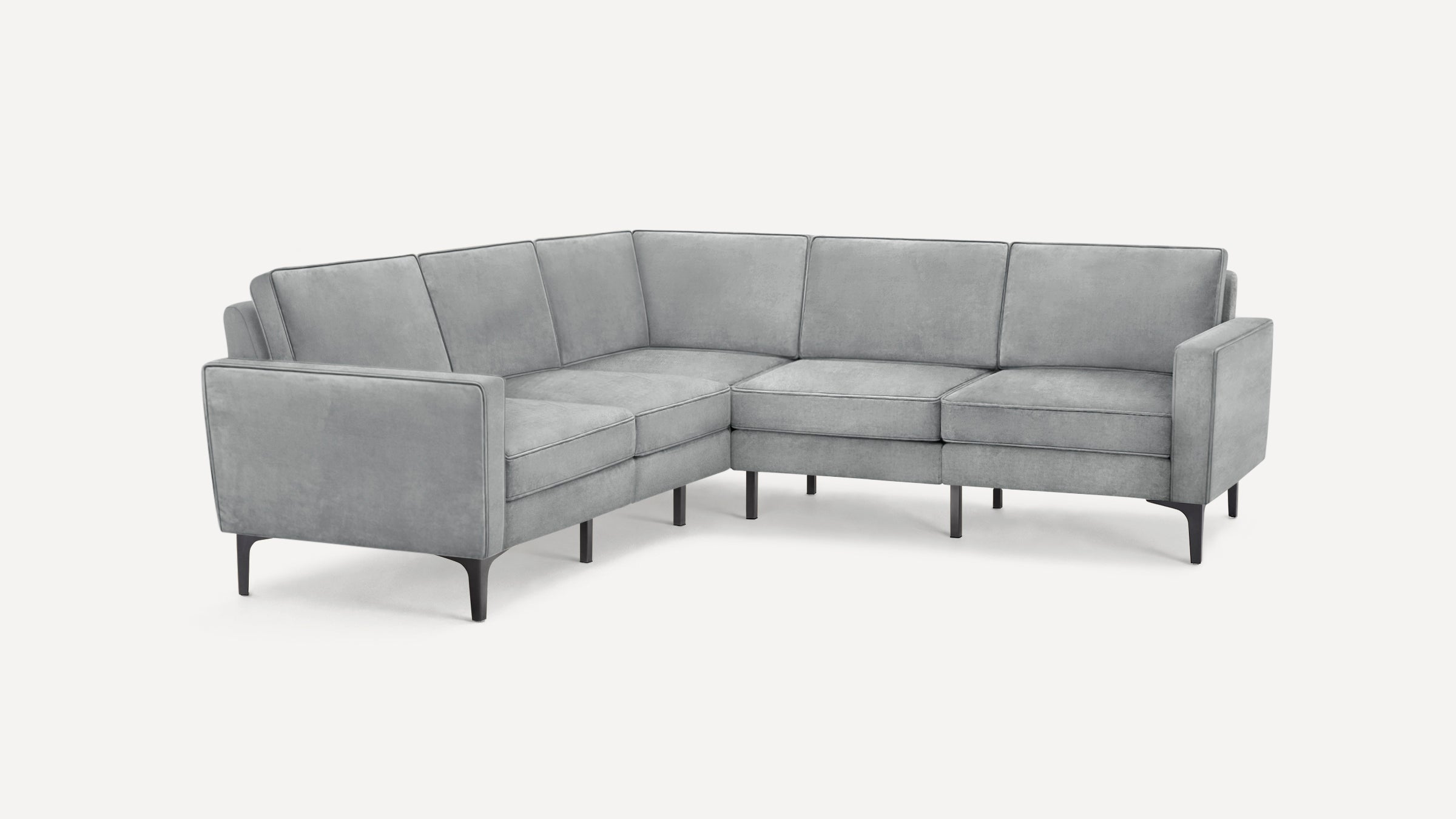 Light gray modern sectional sofa with clean lines, low back cushions, and black slender legs on a white background.