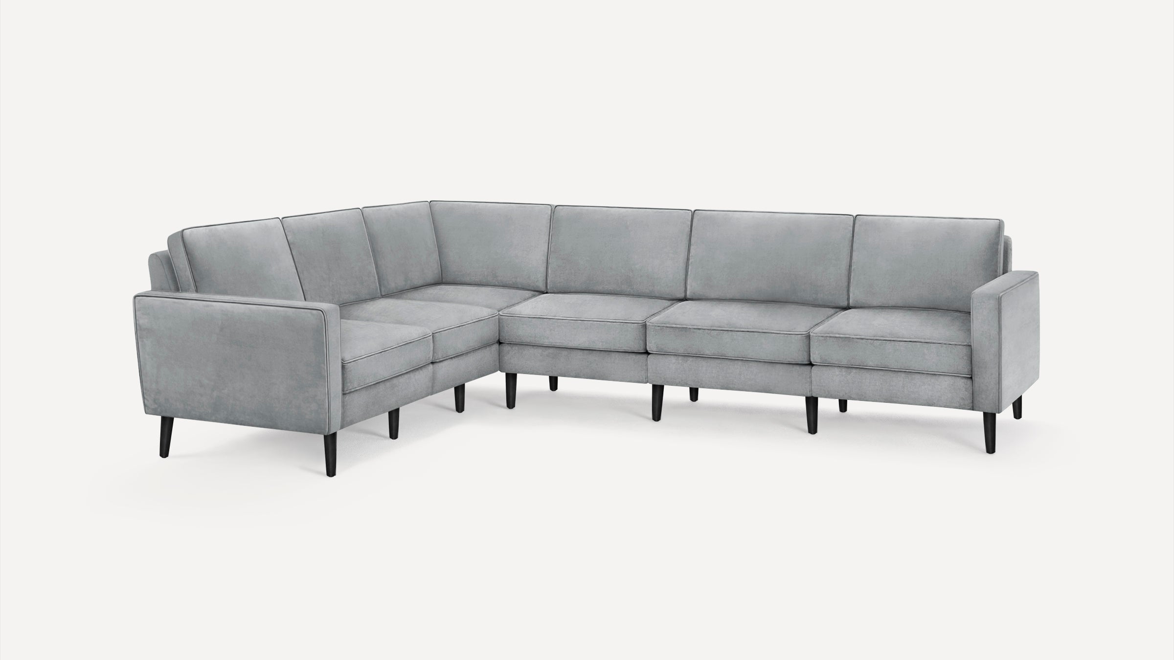 Modern L-shaped sectional sofa upholstered in light gray fabric with slim black legs and streamlined cushions.