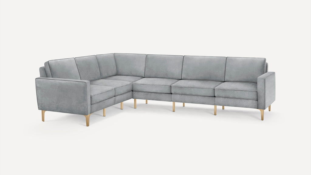Modern L-shaped sectional sofa in light gray upholstery with slim gold metal legs, clean lines, and plush cushions.