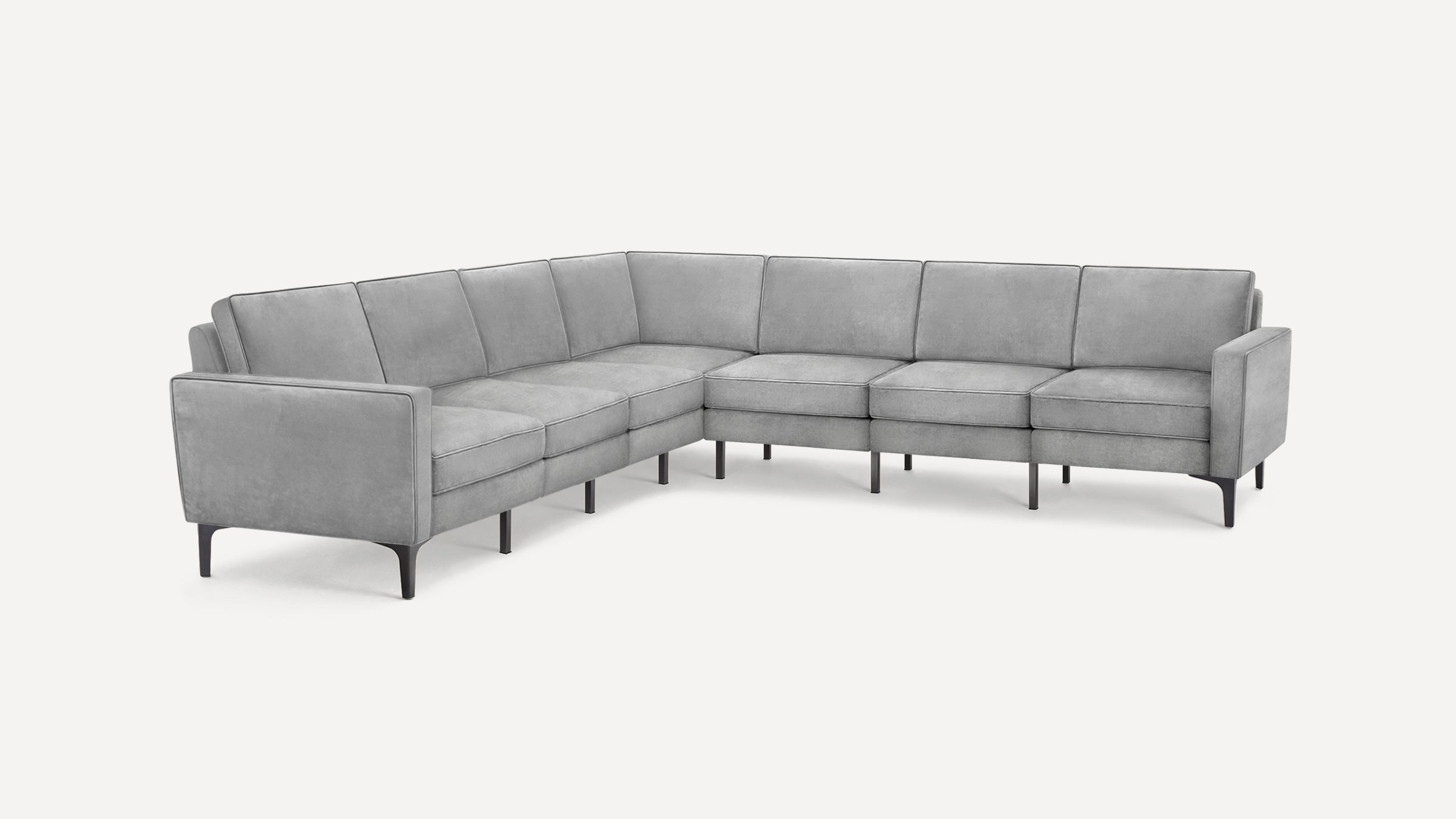 Modern L-shaped sectional sofa in light gray with clean lines, thin black metal legs, and plush cushions, designed for ample seating.