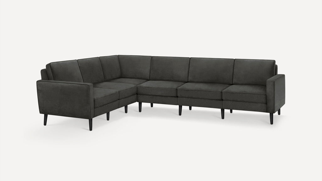 Modern dark grey L-shaped sectional sofa with slim black legs, cushioned seats, and backrests on a white background.