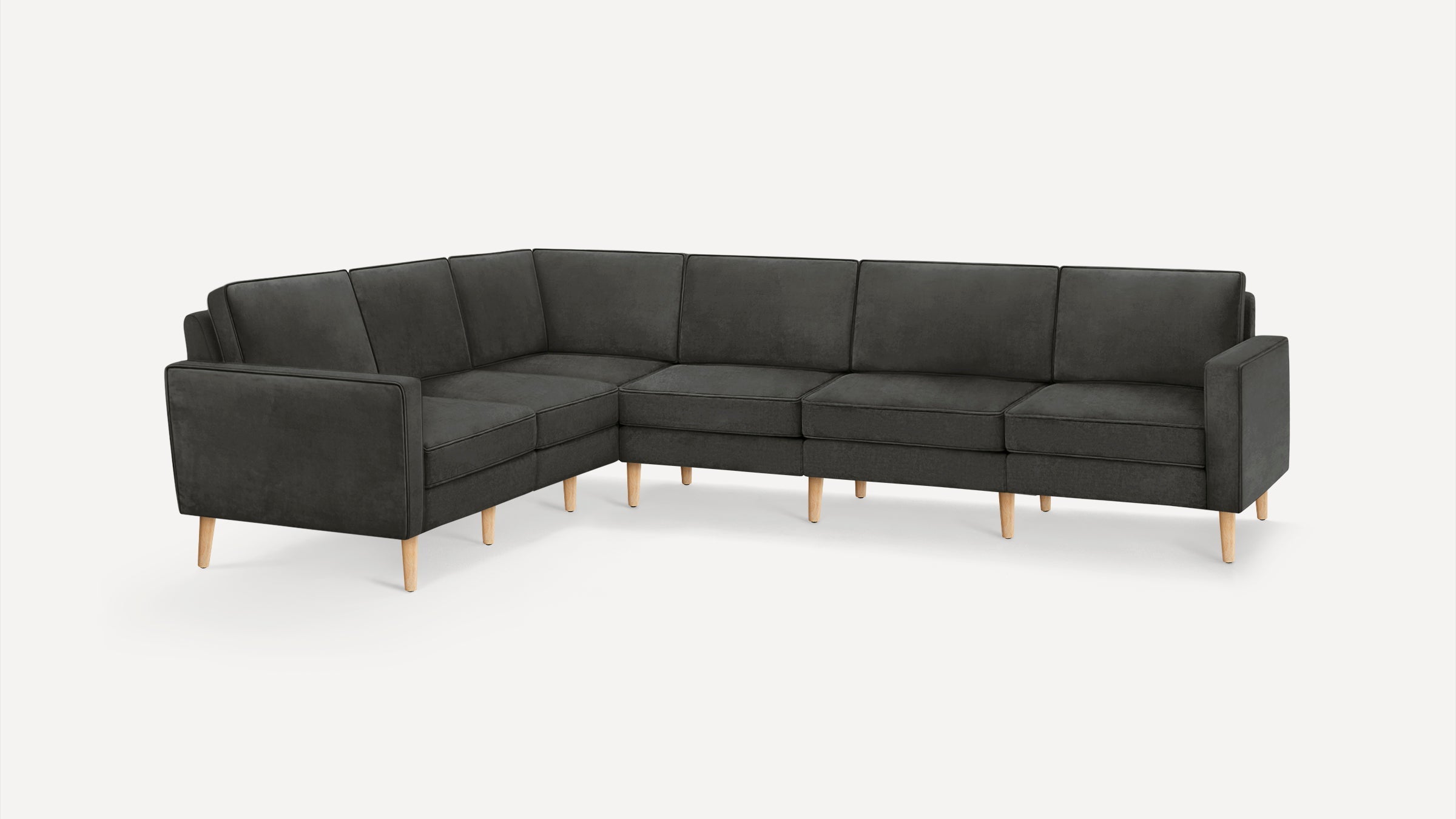 Modern L-shaped sectional sofa in dark gray fabric with wooden tapered legs and clean, straight-lined cushions.