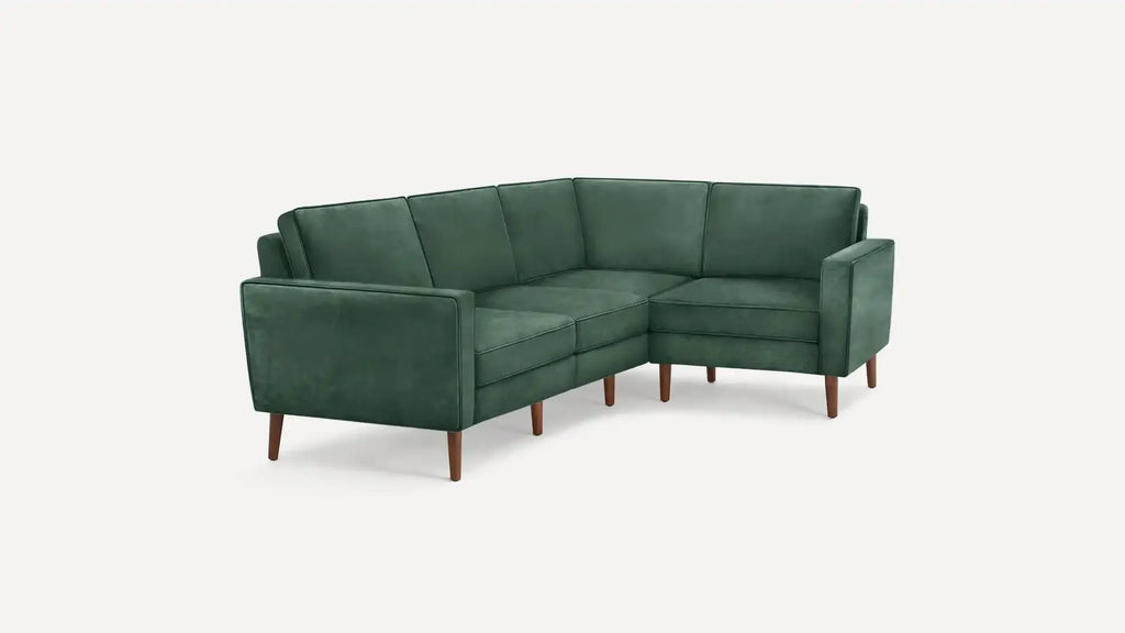 modern green velvet sectional sofa with wooden legs and clean lines on a white background