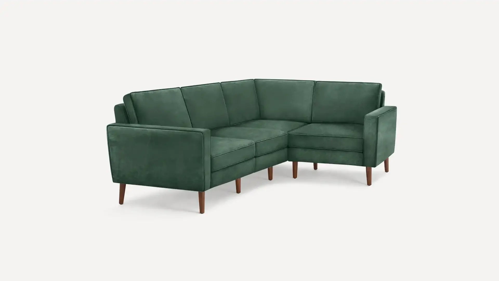 modern green velvet sectional sofa with wooden legs and clean lines on a white background
