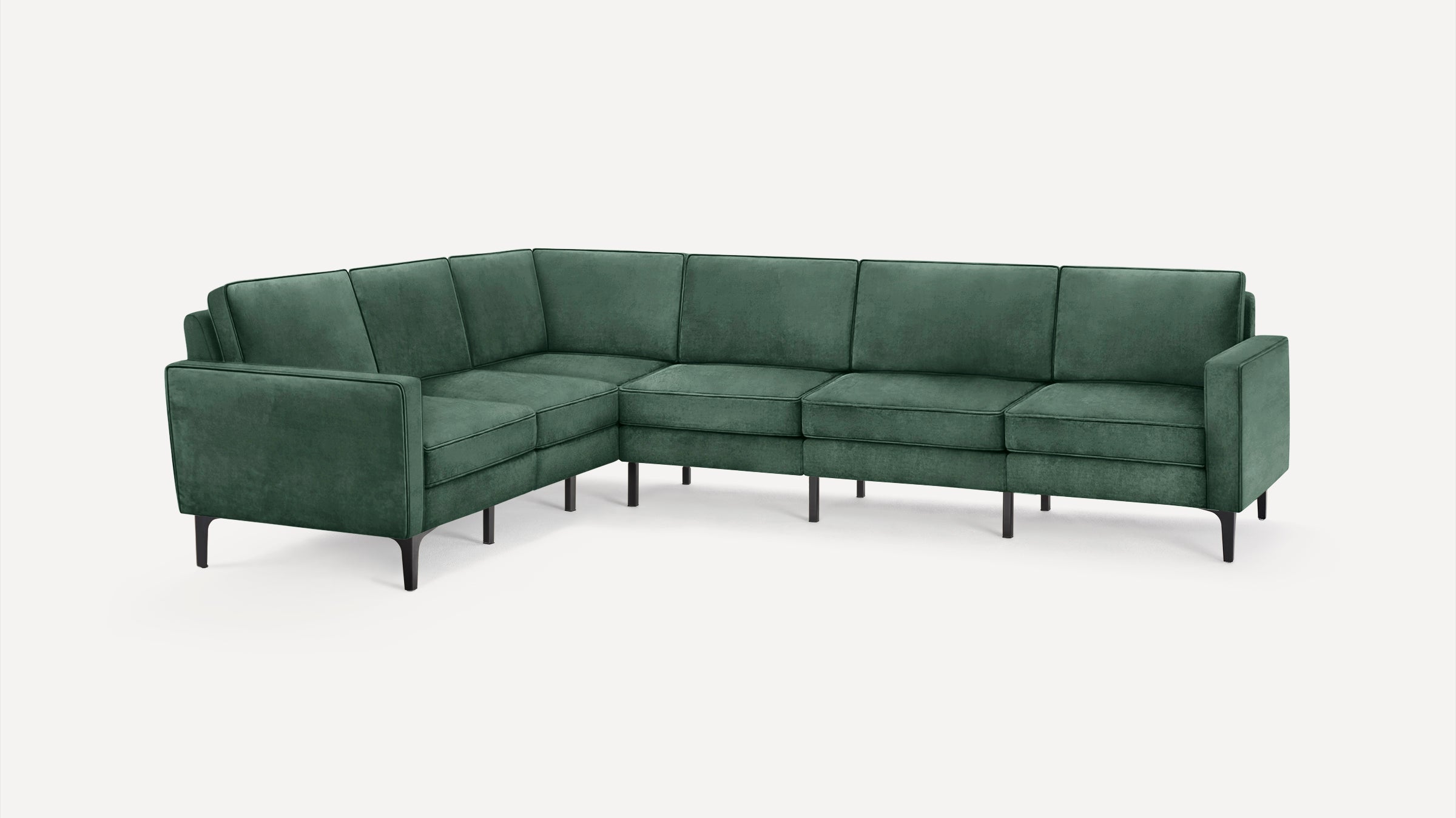 L-shaped sectional sofa in deep green velvet upholstery with sleek black legs and modern, clean lines.