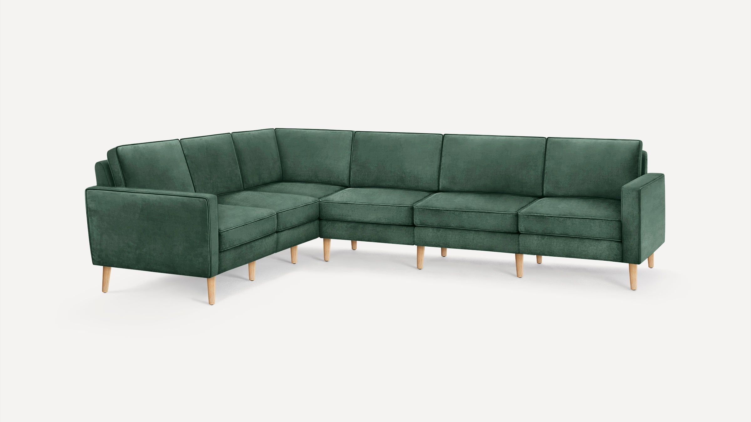 Modern L-shaped sectional sofa in deep green fabric with wooden legs, featuring clean lines and cushioned seats.