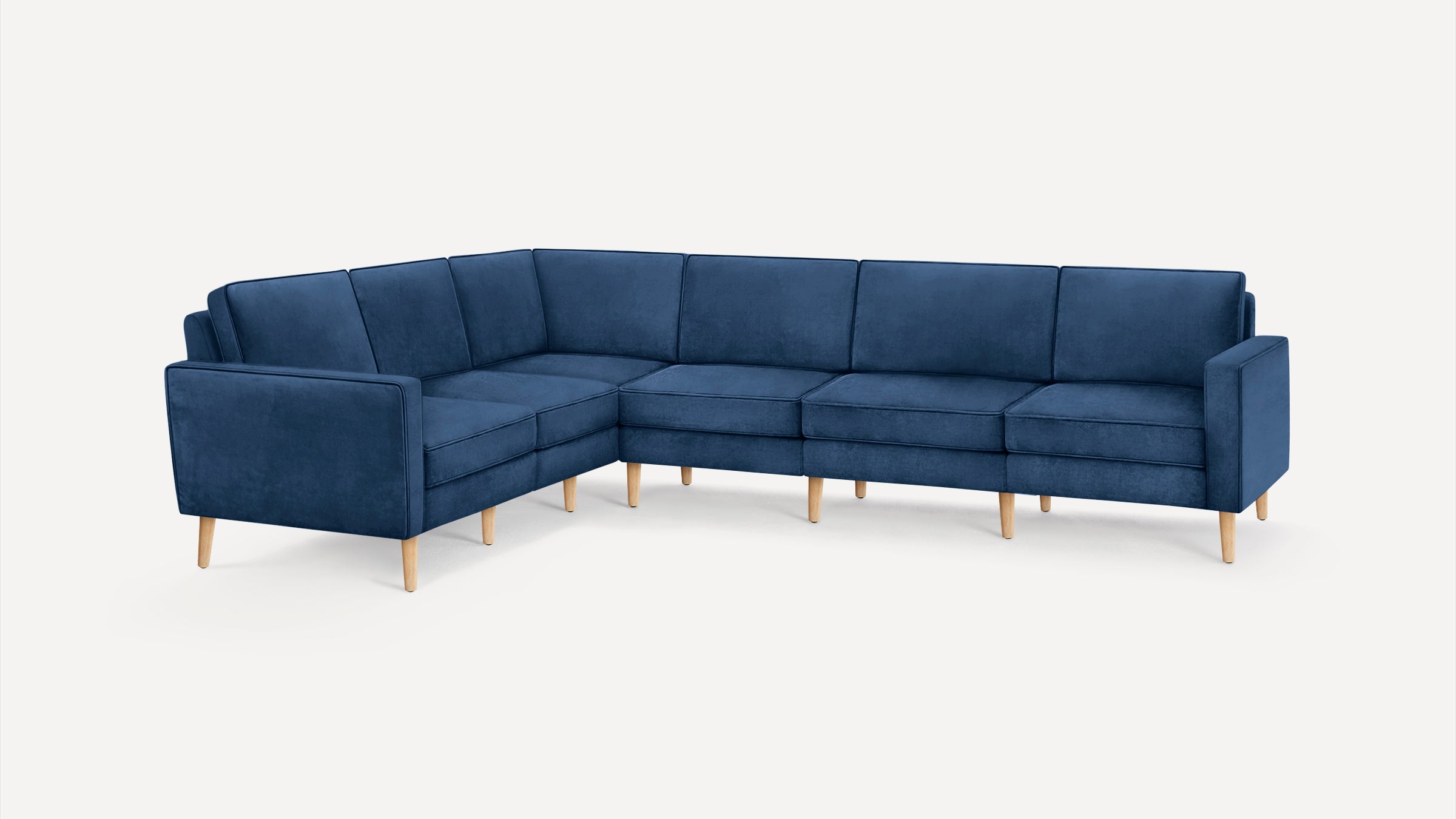 Modern L-shaped sectional sofa with dark blue upholstery and light wooden legs, designed for spacious seating.