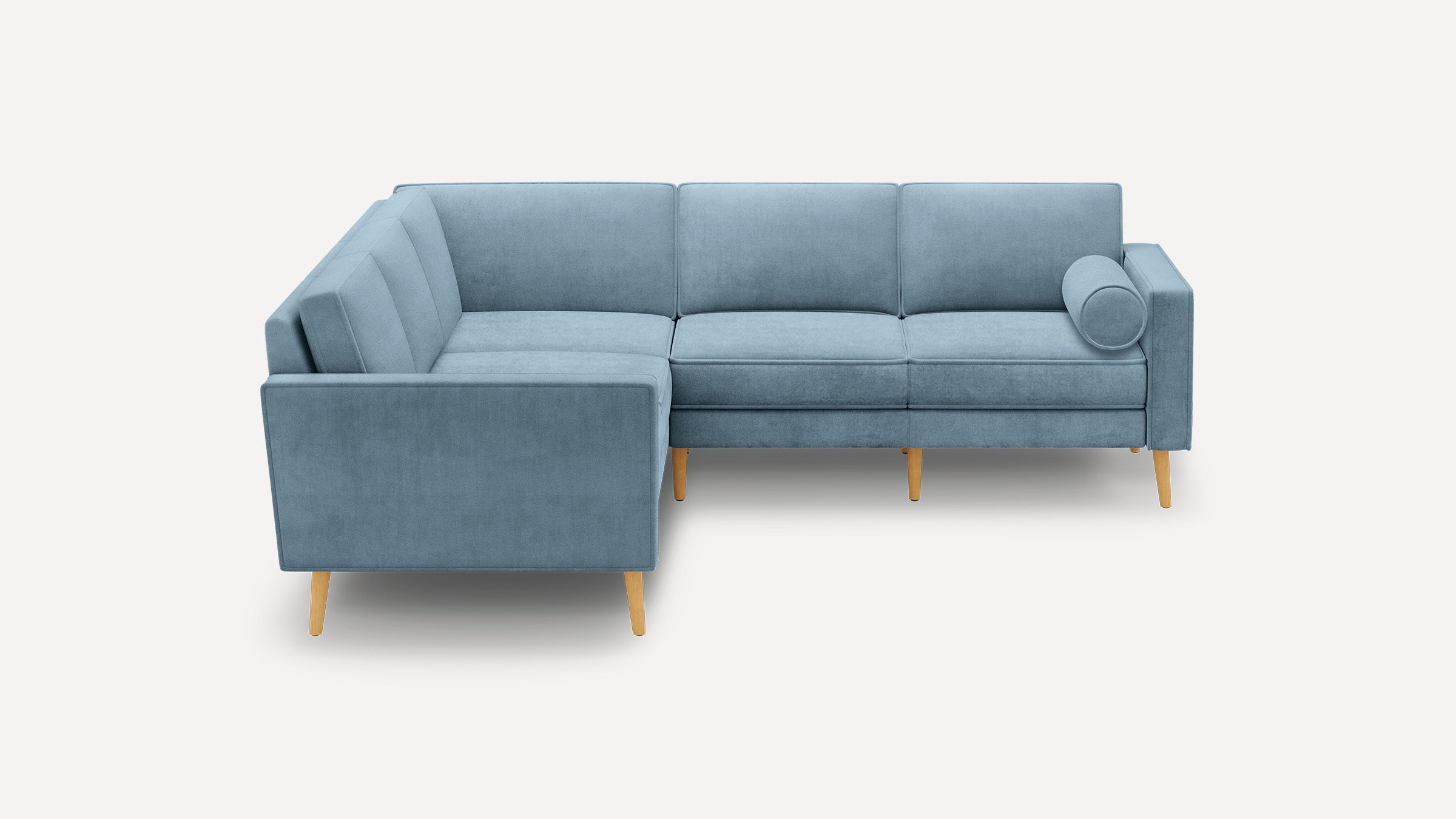 Modern light blue L-shaped sectional sofa with wooden legs and a cylindrical bolster pillow on a plain white background.