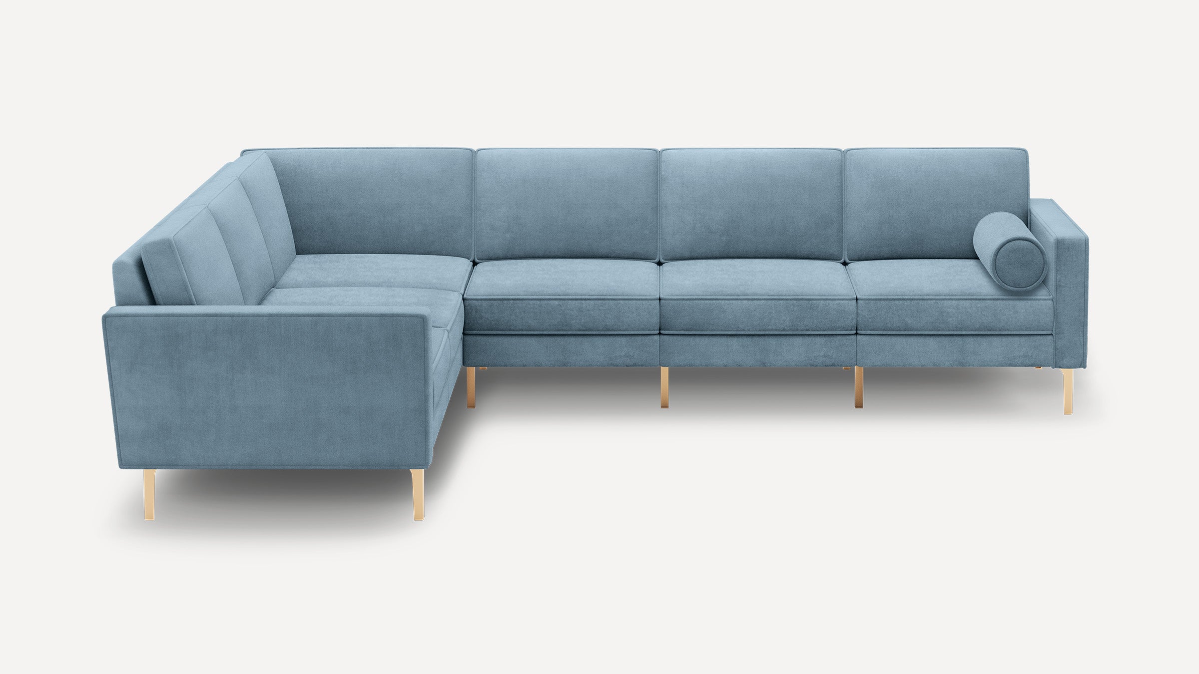 Modern L-shaped sectional sofa upholstered in light blue fabric with straight arms, tufted cushions, brass legs, and a round bolster pillow.