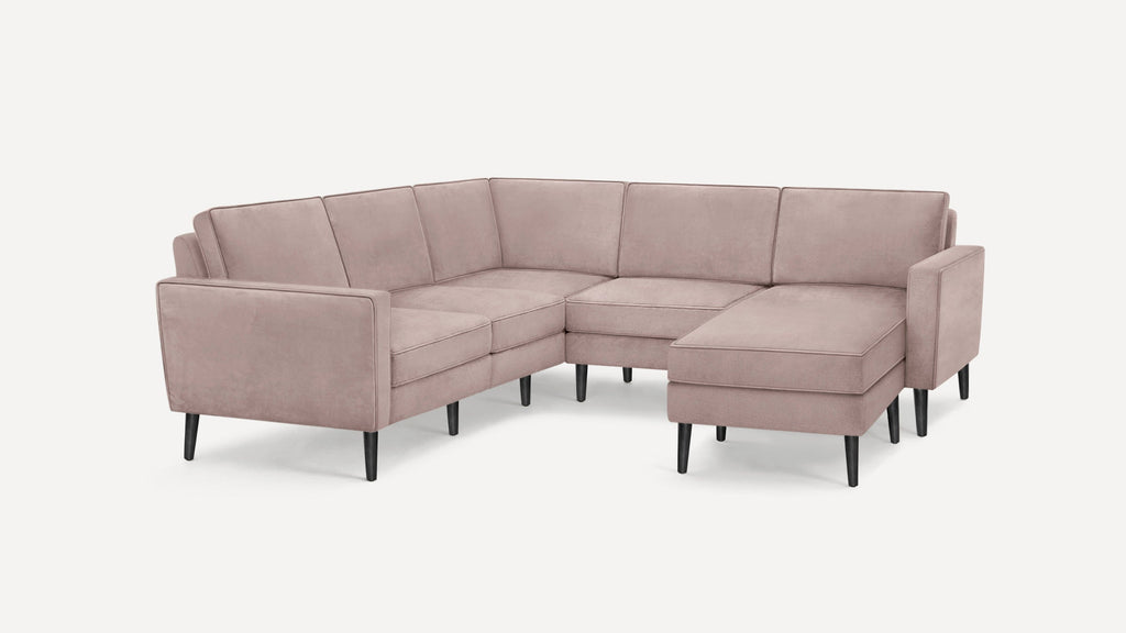 Light pink velvet L-shaped sectional sofa with black tapered legs and clean, modern design.