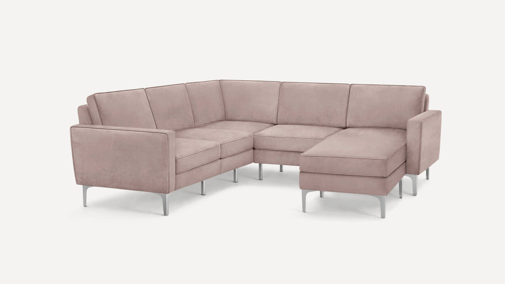 Modern L-shaped sectional sofa in dusty pink fabric with slim metallic legs and clean, straight armrests.